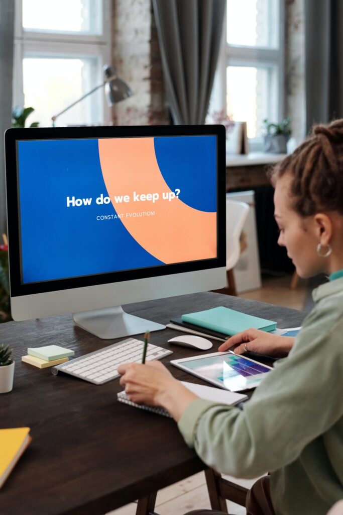 Woman working on computer with motivational screen message.