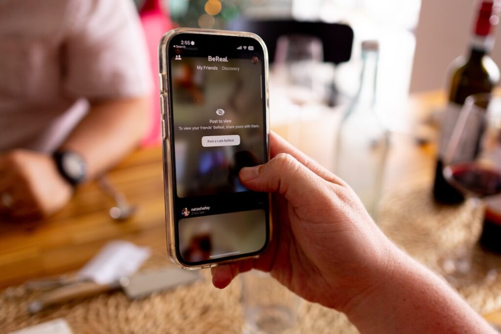 Person using BeReal app on smartphone indoors.