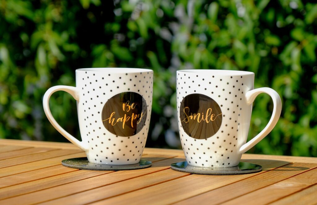 Two polka-dotted mugs with motivational quotes outdoors