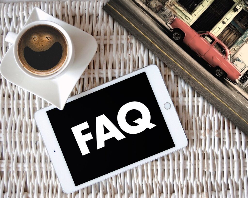 Tablet with FAQ, coffee cup, vintage car background.