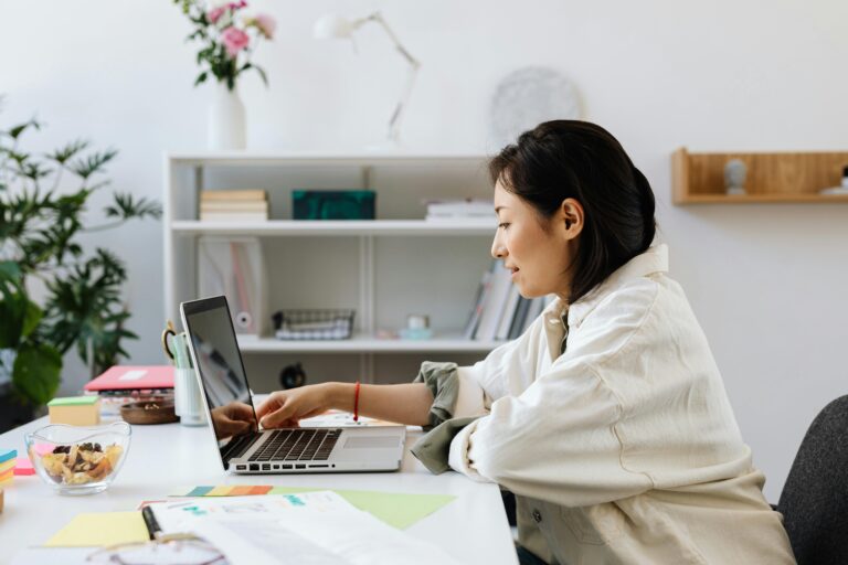 Woman working on laptop in bright home office