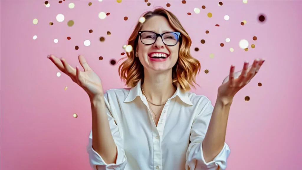 Joyful woman with confetti on pink background