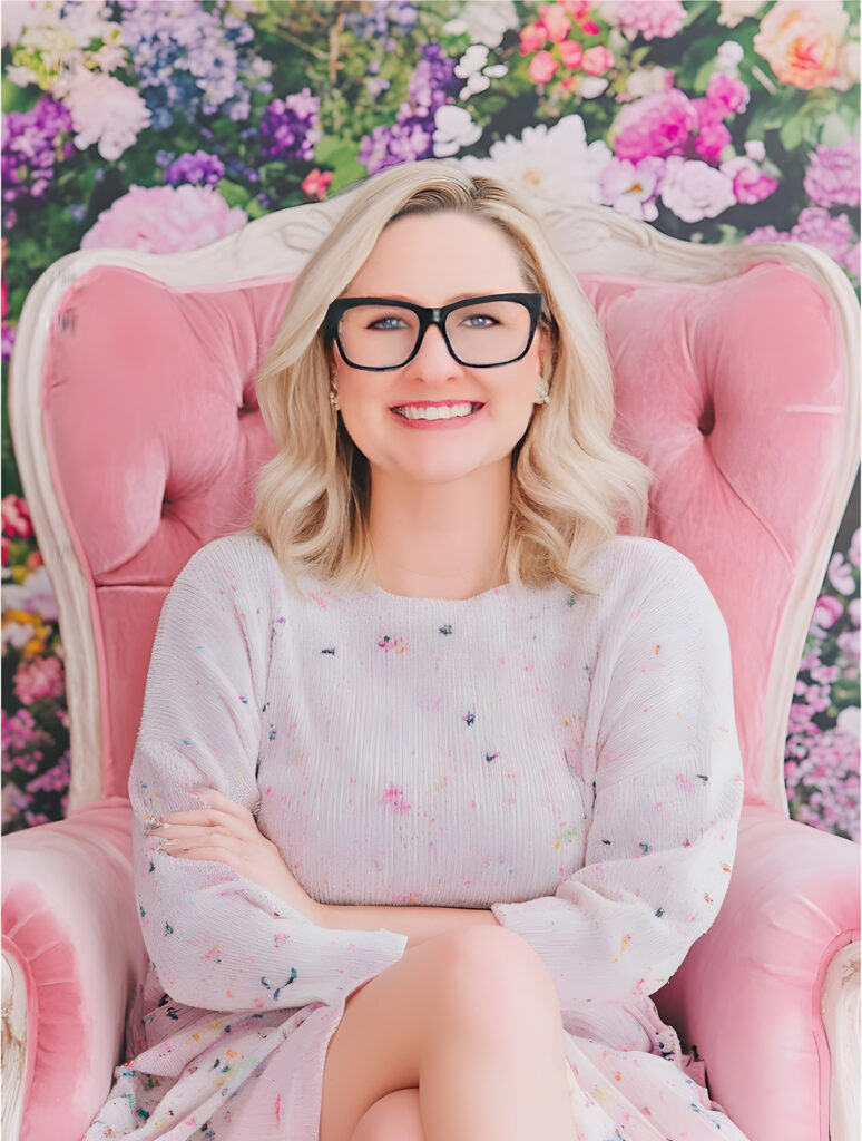 Woman smiling in pink chair against floral background
