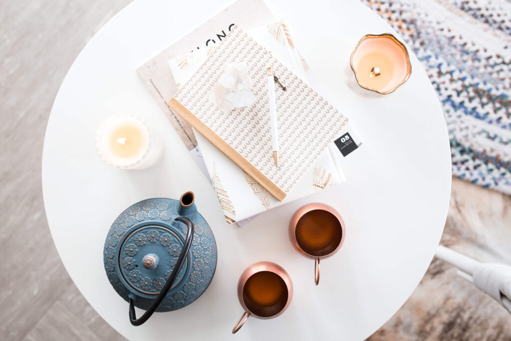 Cozy tea setup with notebooks and candles.