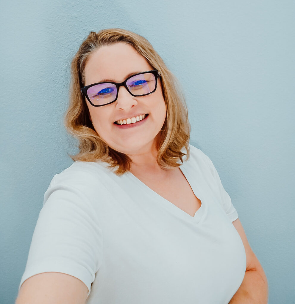 Person smiling against a light blue background.