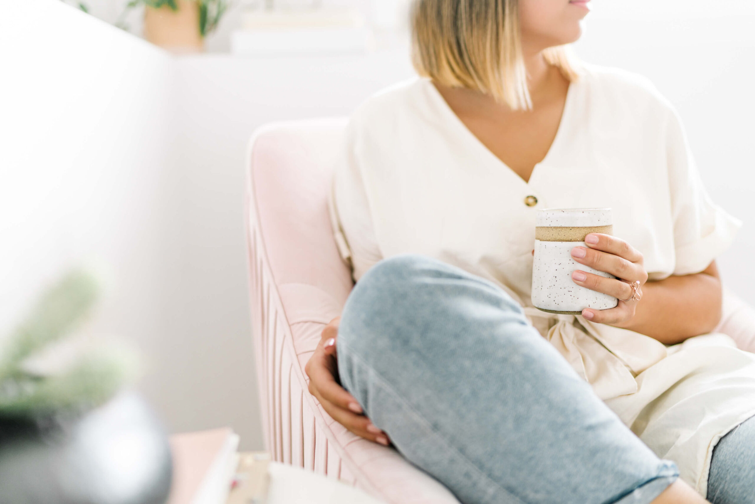 Person relaxing with mug on pink chair