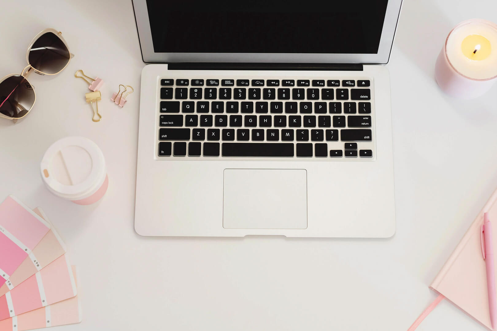 Laptop on desk with coffee and accessories.