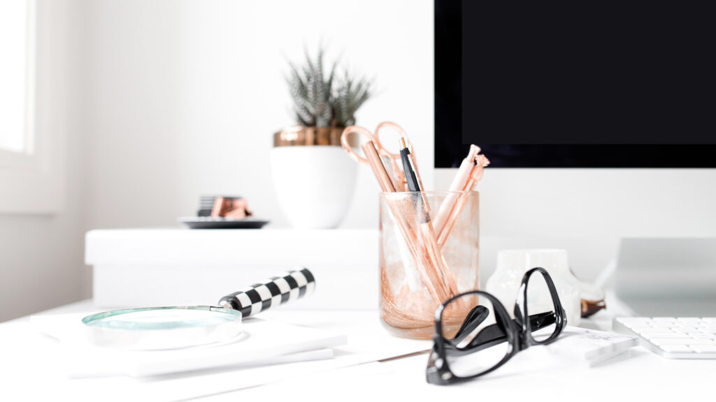 Minimalist desk with office supplies and computer screen.