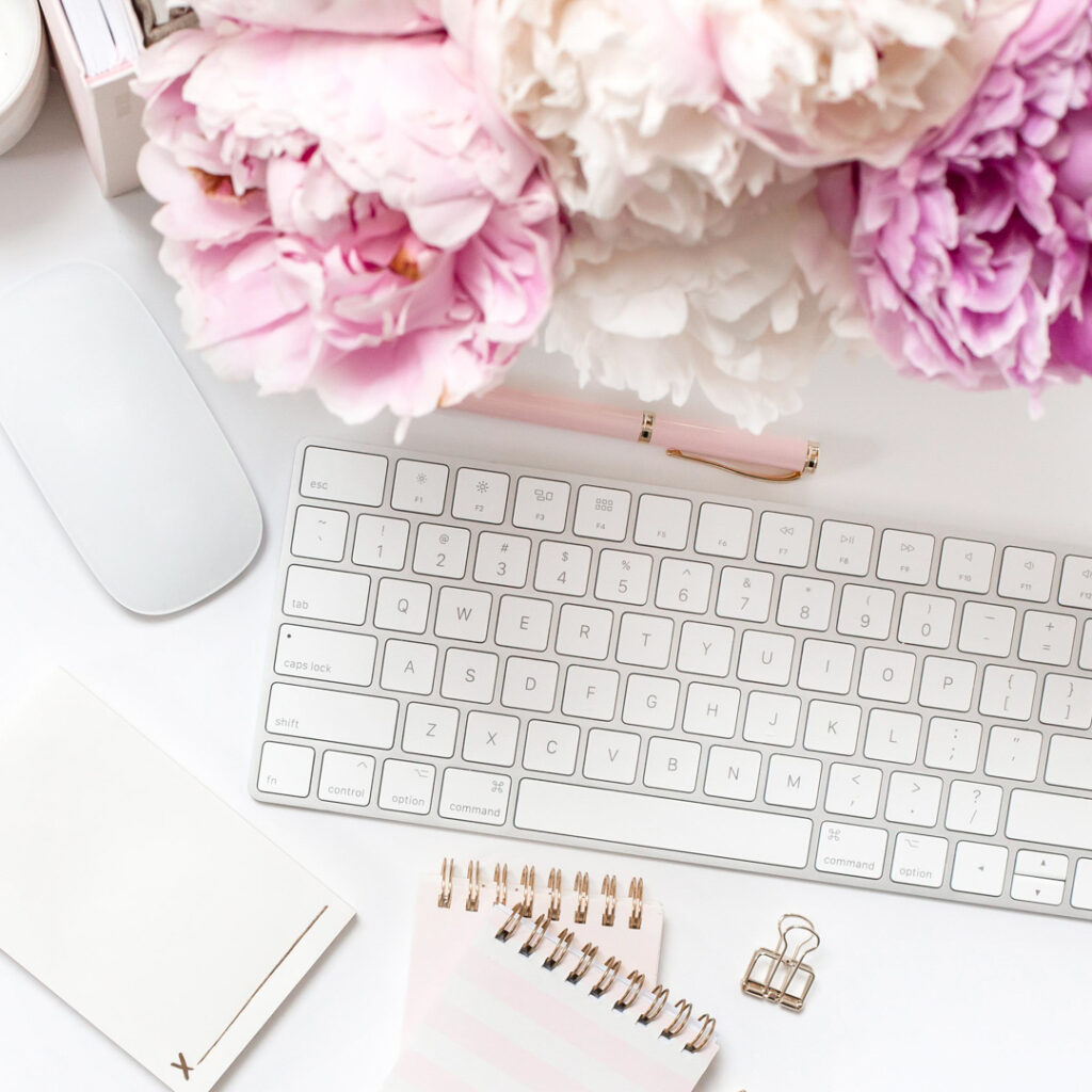 White desk with keyboard, flowers, and mouse