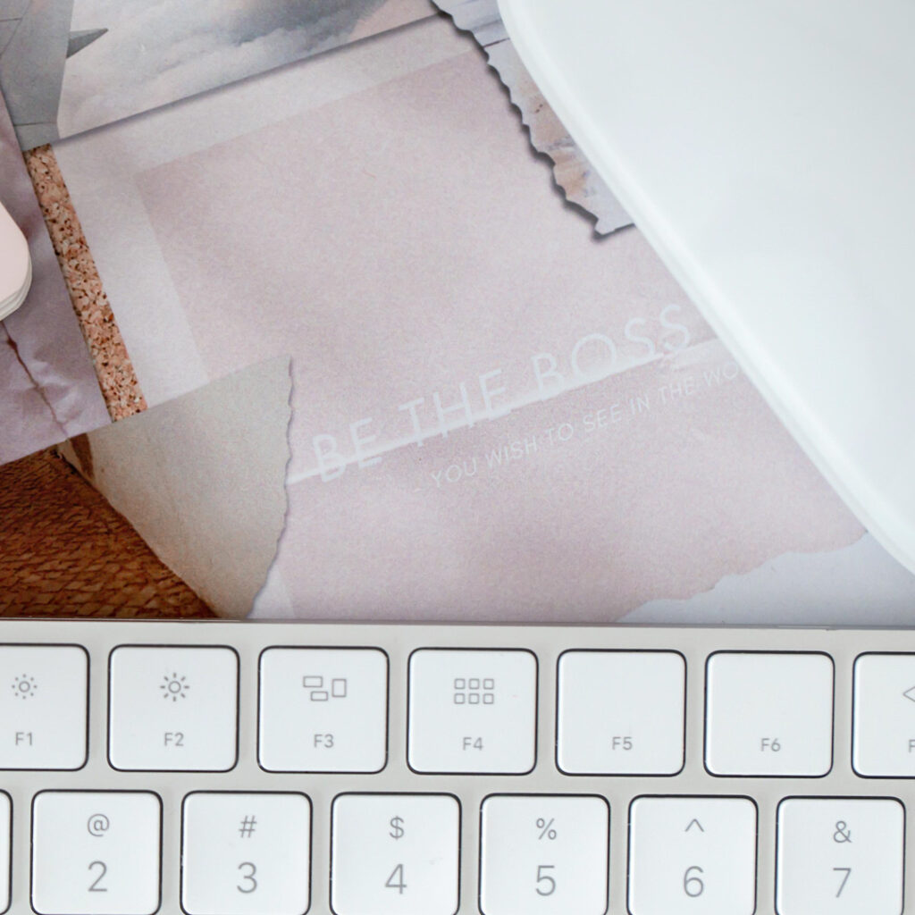 Pink notepad, keyboard, and motivational poster