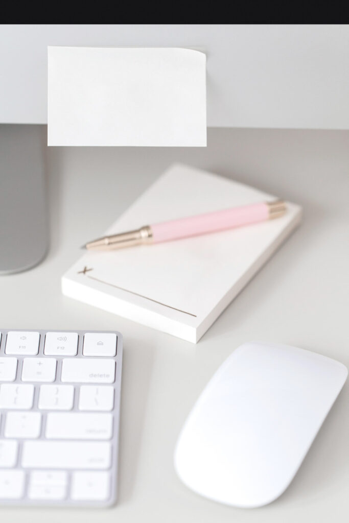 White desk setup with notepad and keyboard