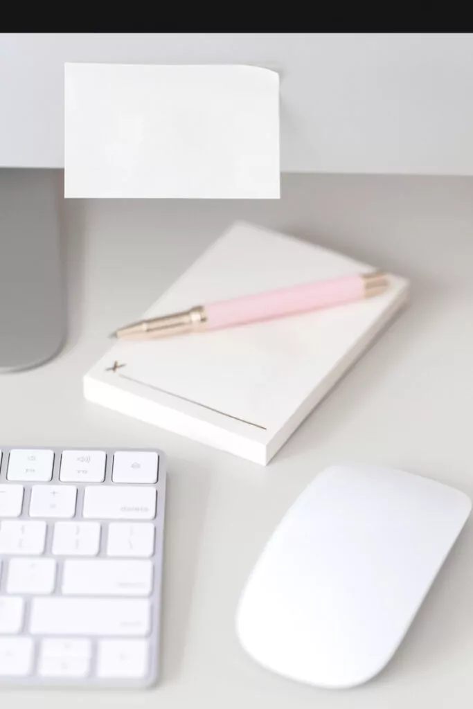 White desk setup with notepad and keyboard