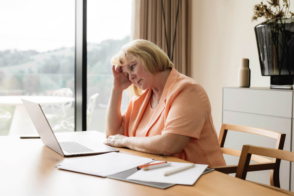 Woman looking stressed at laptop
