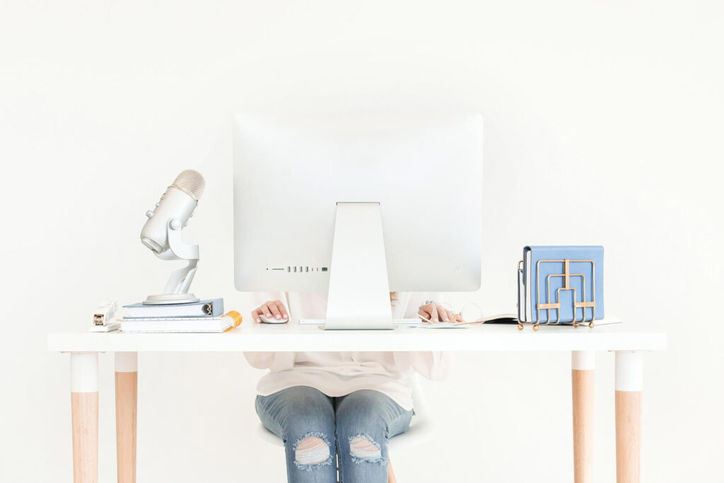 Person working at a minimalist desk with computer.