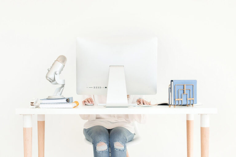 Person working at a minimalist desk with computer.