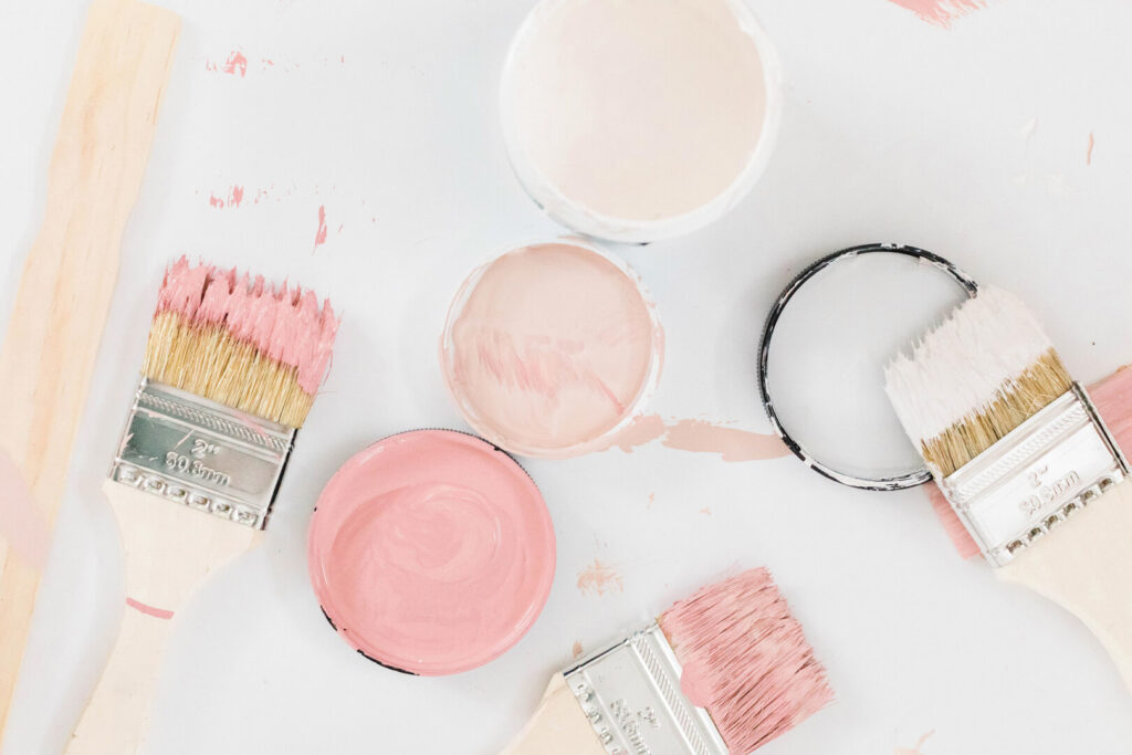Paintbrushes and cans with pink paint
