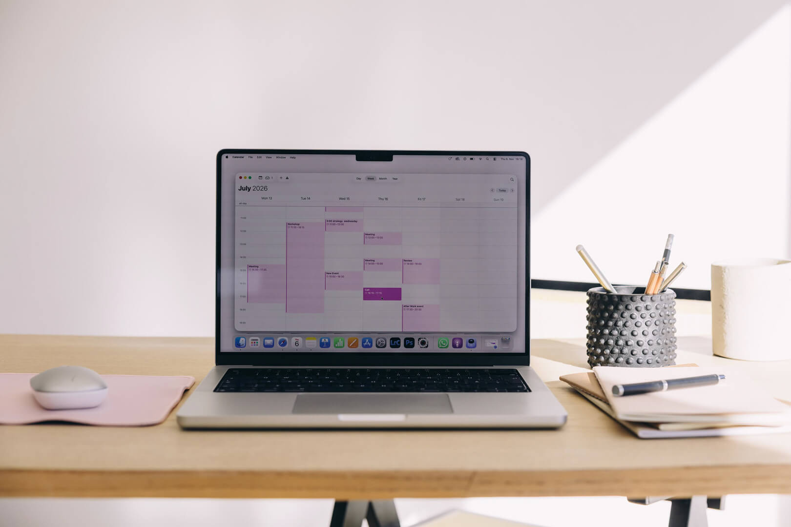 Laptop displaying calendar on minimalist desk setup