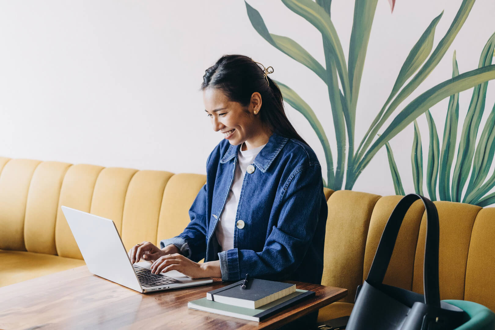 Woman smiling while working on laptop in cafe