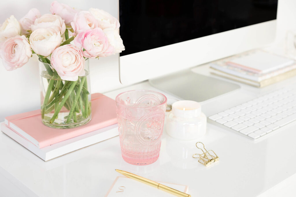 Two notebooks on marble table with blurred flowers