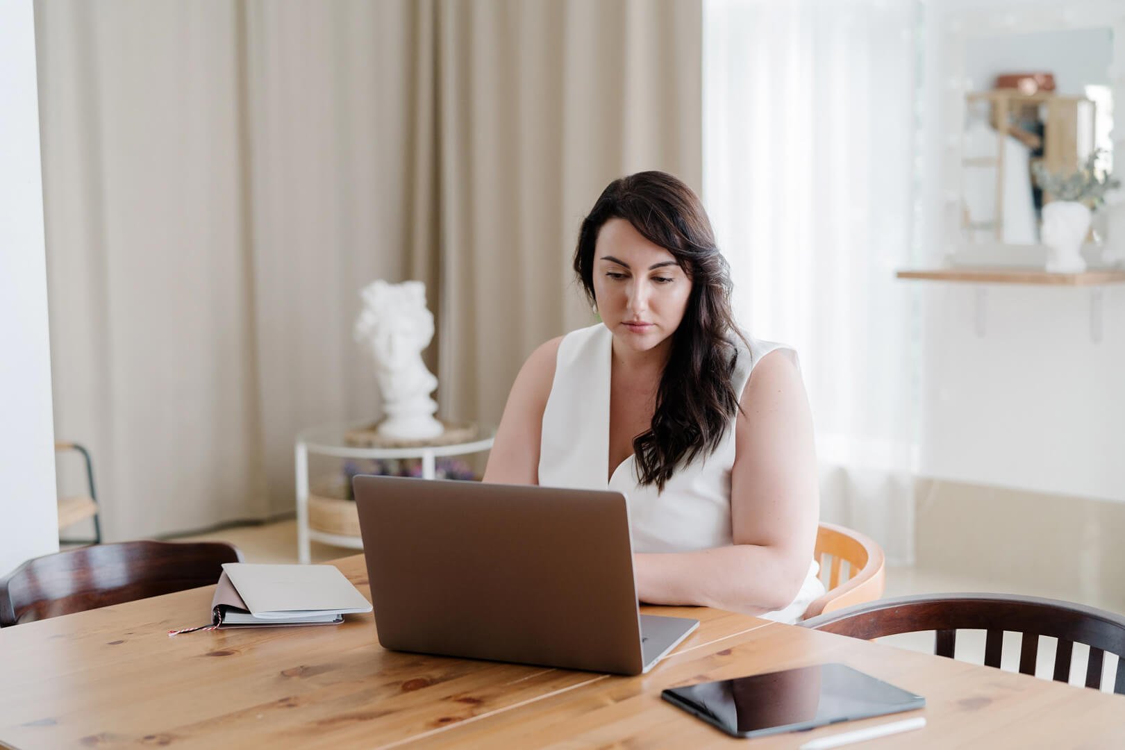 Woman working on laptop at home office table
