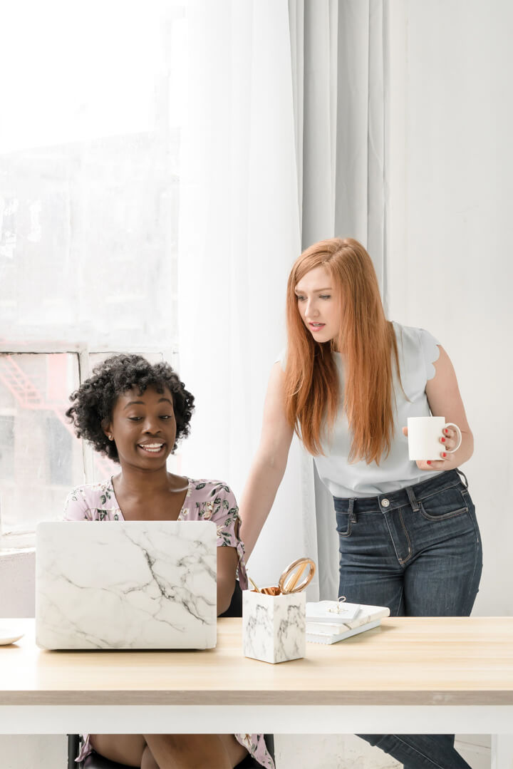 Two women working together at a laptop