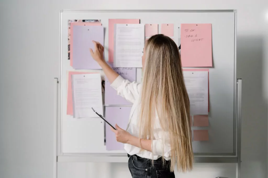 Woman organizing notes on office whiteboard