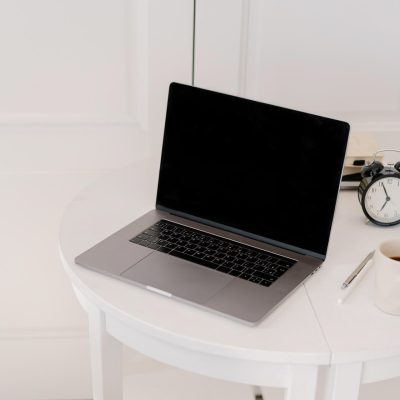 Laptop on small white table with coffee