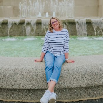 Woman sitting in front of fountain smiling